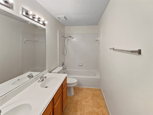 full bathroom featuring tiled shower / bath, a textured ceiling, toilet, vanity, and tile patterned floors