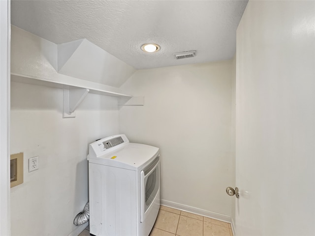 laundry area featuring washer / dryer, a textured ceiling, and light tile patterned floors