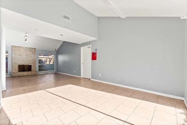 unfurnished living room with light tile patterned floors, lofted ceiling, and a brick fireplace