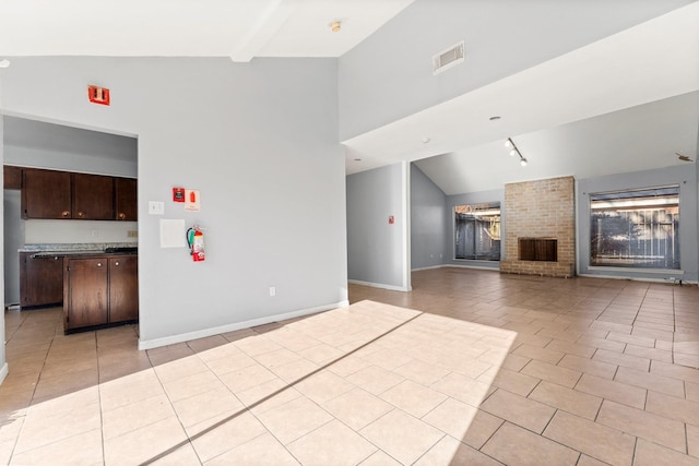 unfurnished living room featuring beam ceiling, light tile patterned flooring, high vaulted ceiling, and a brick fireplace