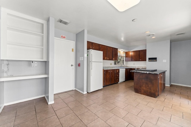 kitchen with sink, a center island, dark brown cabinets, and white appliances