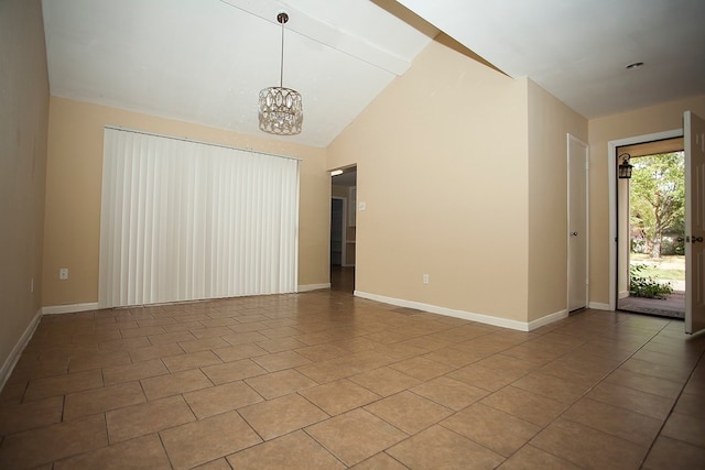 empty room featuring tile patterned floors, vaulted ceiling, and a chandelier