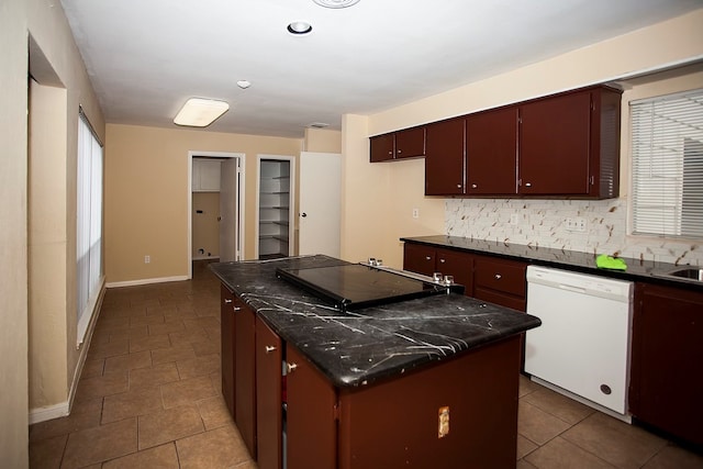 kitchen with tasteful backsplash, tile patterned flooring, white dishwasher, and a kitchen island