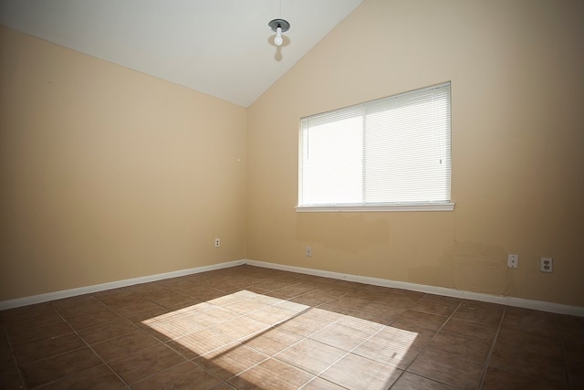 unfurnished room with high vaulted ceiling and dark tile patterned flooring