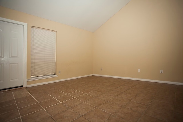 tiled empty room with vaulted ceiling