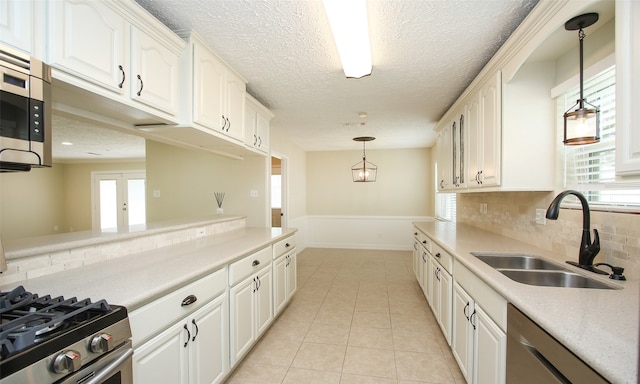 kitchen featuring appliances with stainless steel finishes, hanging light fixtures, sink, and plenty of natural light