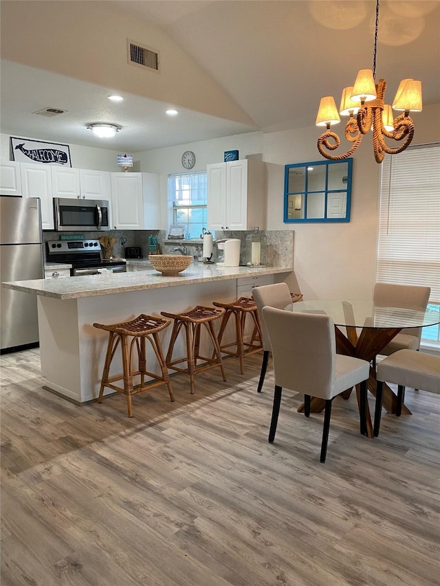 4034 Panola Dr, Galveston, TX 77554 - dining space featuring vaulted ceiling, light wood-style floors, a chandelier, and recessed lighting
