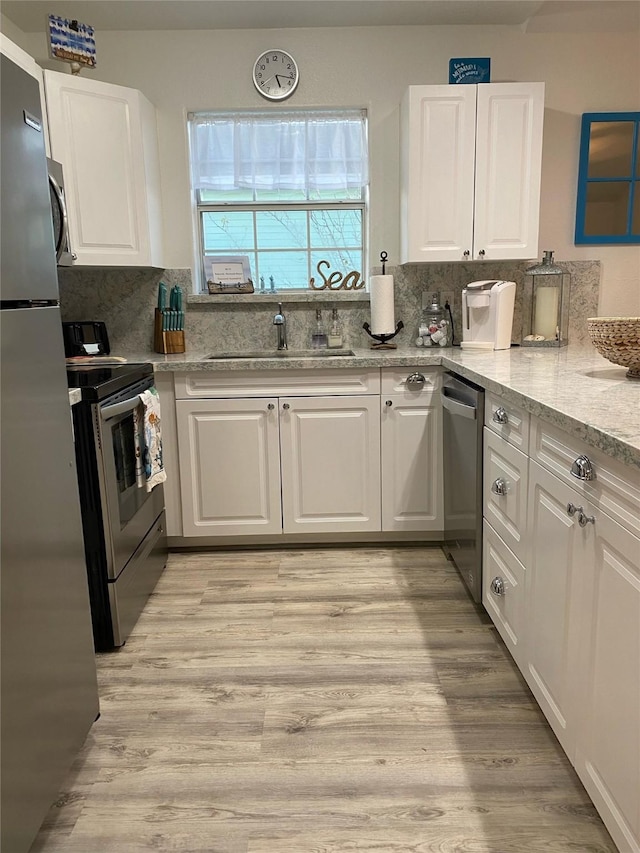 4034 Panola Dr, Galveston, TX 77554 - kitchen with stainless steel appliances, a sink, white cabinets, and decorative backsplash