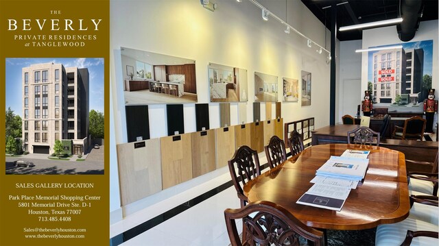 dining space with rail lighting and a high ceiling