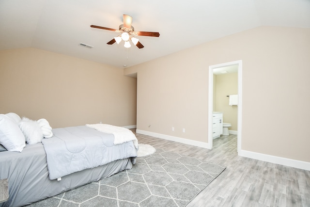 bedroom featuring light hardwood / wood-style floors, lofted ceiling, connected bathroom, and ceiling fan