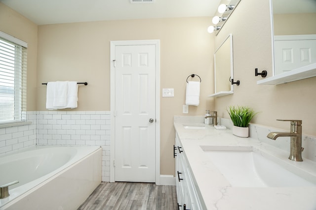 bathroom featuring vanity, hardwood / wood-style floors, and a bathtub