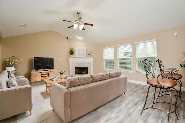 living room featuring light hardwood / wood-style flooring, lofted ceiling, and ceiling fan