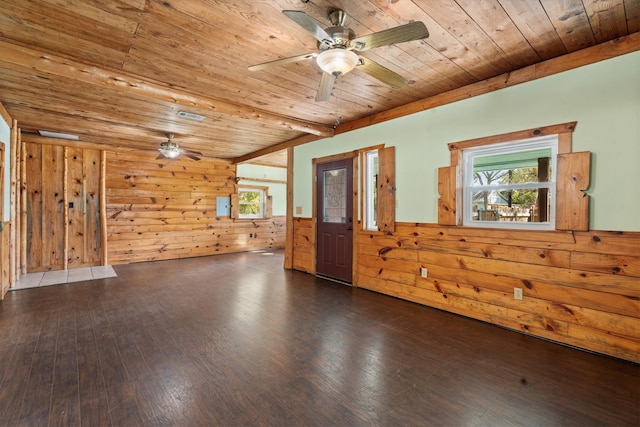 spare room featuring wood walls, dark wood-type flooring, wood ceiling, and plenty of natural light