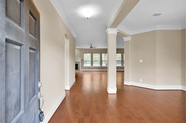 entryway featuring ceiling fan, wood-type flooring, ornate columns, and ornamental molding