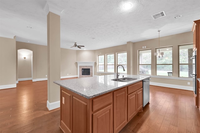 kitchen featuring sink, light stone counters, a center island with sink, and dark hardwood / wood-style floors