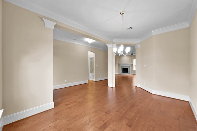 interior space with hardwood / wood-style flooring, ornamental molding, and a notable chandelier