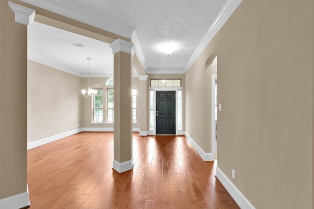 foyer entrance with ornamental molding, wood-type flooring, and a chandelier