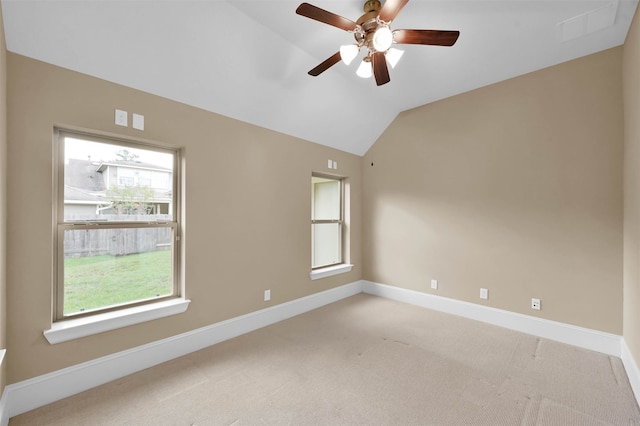 empty room featuring ceiling fan, vaulted ceiling, and a healthy amount of sunlight