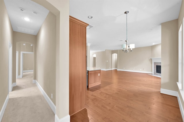 corridor featuring a chandelier and light hardwood / wood-style floors