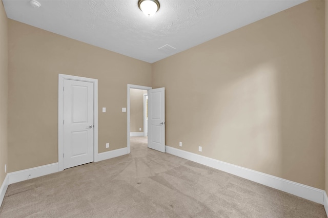 unfurnished bedroom with a textured ceiling and light carpet