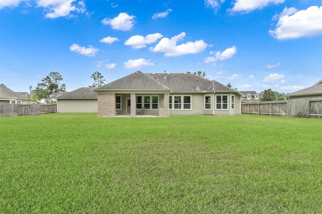 back of property with a patio and a yard