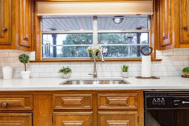 kitchen with black dishwasher, backsplash, and sink