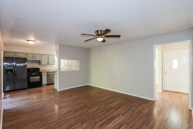 unfurnished living room featuring ceiling fan, a textured ceiling, and dark hardwood / wood-style flooring