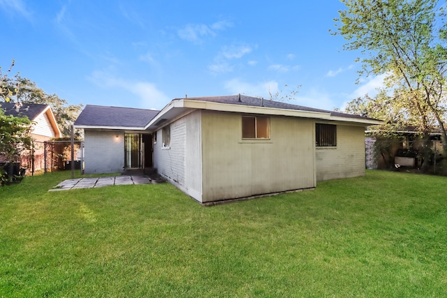 rear view of house with a yard and a patio