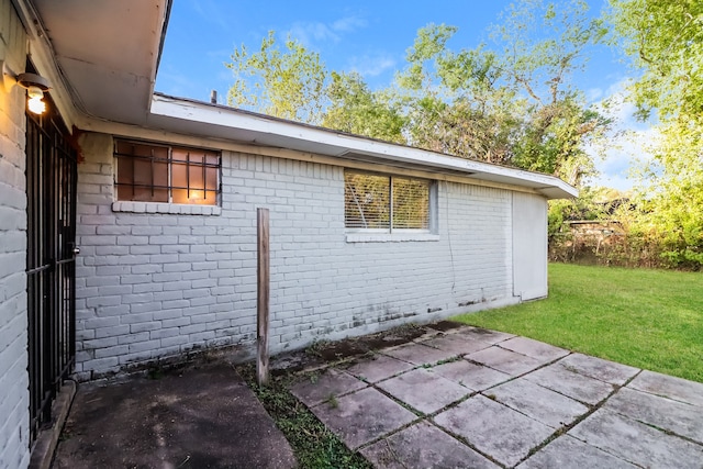 view of home's exterior with a yard and a patio area