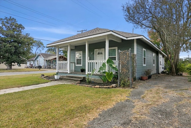 bungalow-style home with covered porch and a front lawn