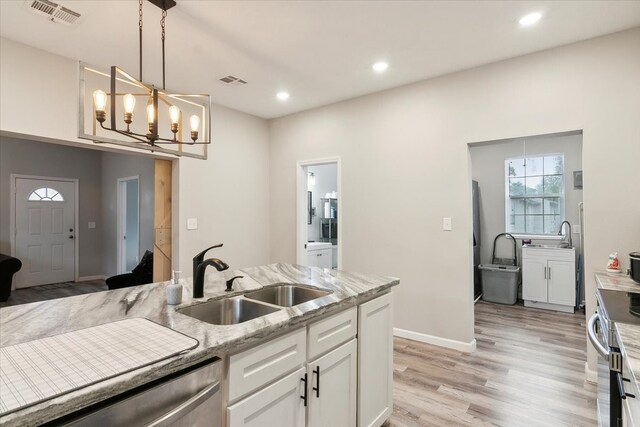 kitchen with hanging light fixtures, an inviting chandelier, white cabinetry, light hardwood / wood-style floors, and sink