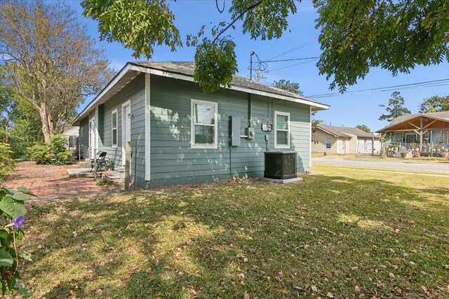 view of home's exterior with cooling unit and a yard