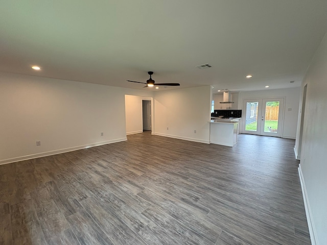 unfurnished living room featuring ceiling fan, french doors, and dark wood-type flooring