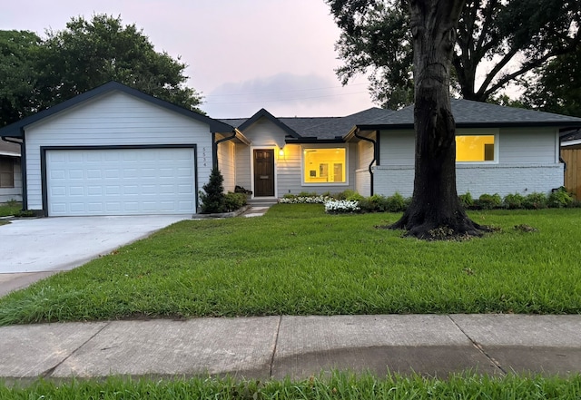 single story home with a garage and a lawn