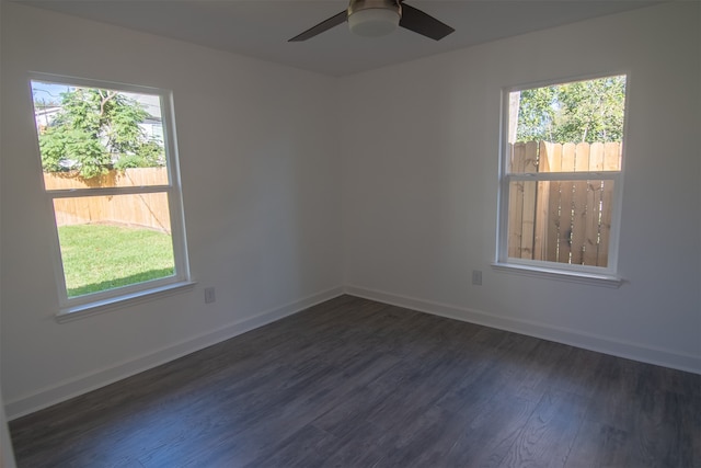 spare room with a wealth of natural light, dark wood-type flooring, and ceiling fan