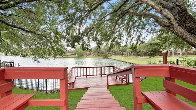 wooden terrace featuring a water view and a yard