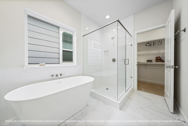 bathroom featuring shower with separate bathtub