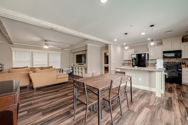 dining room with dark hardwood / wood-style flooring, ornamental molding, and ceiling fan