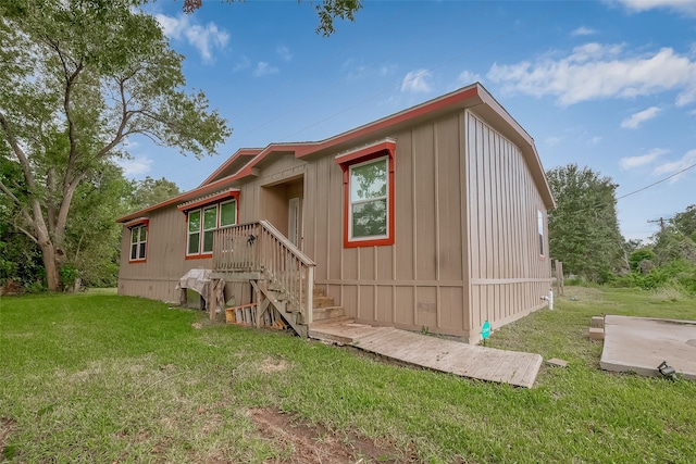 rear view of property featuring a lawn