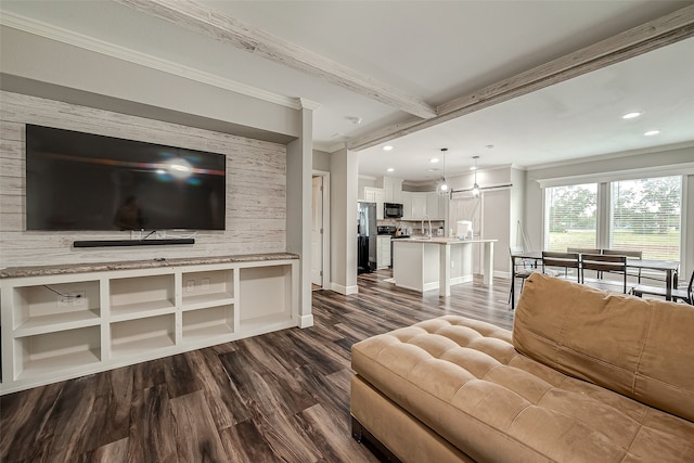 living room featuring crown molding, dark hardwood / wood-style floors, beamed ceiling, and sink