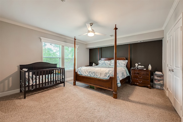 carpeted bedroom with ceiling fan and ornamental molding