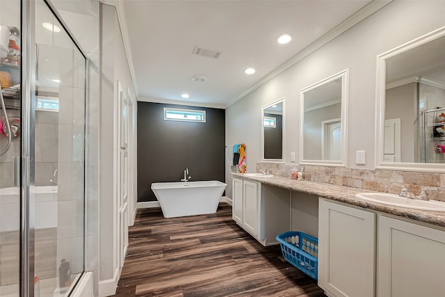 bathroom featuring vanity, crown molding, hardwood / wood-style flooring, and separate shower and tub