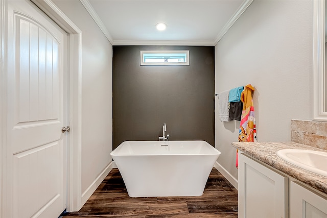 bathroom featuring vanity, crown molding, wood-type flooring, and a washtub