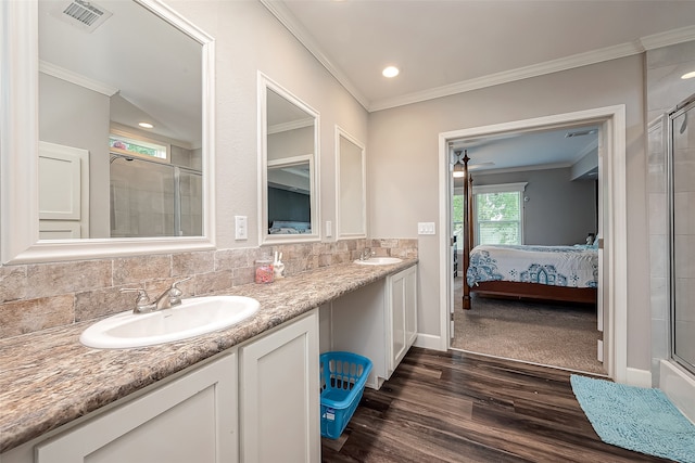 bathroom featuring vanity, an enclosed shower, hardwood / wood-style floors, and tasteful backsplash