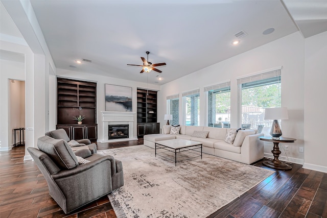 living room with dark wood-type flooring and ceiling fan