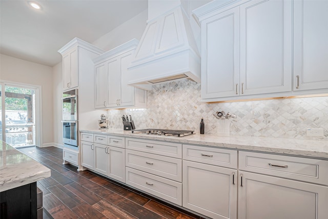 kitchen featuring stainless steel appliances, dark hardwood / wood-style flooring, white cabinets, custom exhaust hood, and backsplash