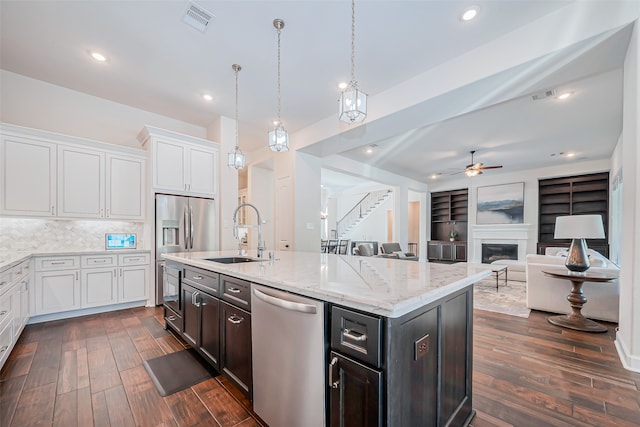 kitchen featuring white cabinetry, built in shelves, sink, and appliances with stainless steel finishes