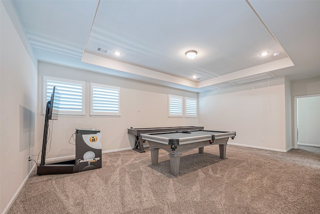 recreation room featuring a tray ceiling and carpet