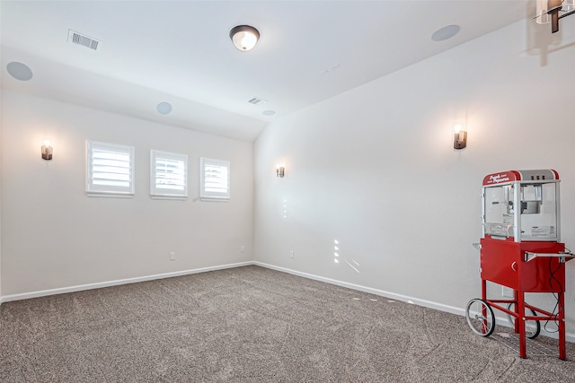 spare room featuring lofted ceiling and carpet floors