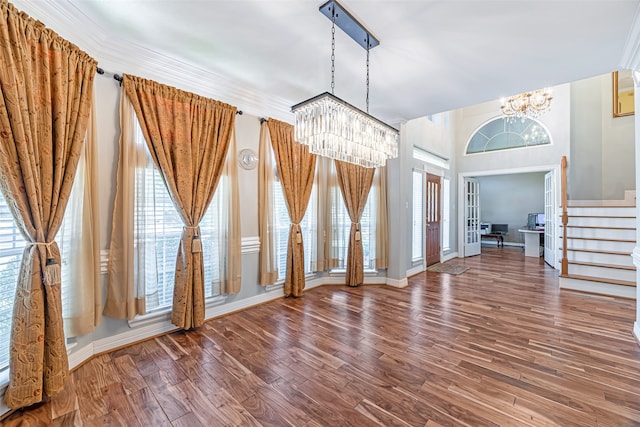 unfurnished dining area with dark hardwood / wood-style floors and an inviting chandelier